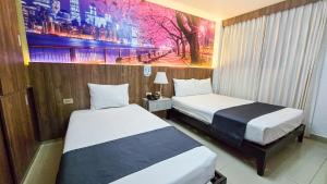 a hotel room with two beds and a painting on the wall at Yours Hotel Lifestyle in Chiclayo