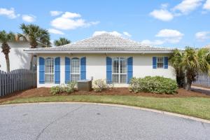 a white house with blue windows and a fence at Seas The Day by Newman-Dailey in Destin