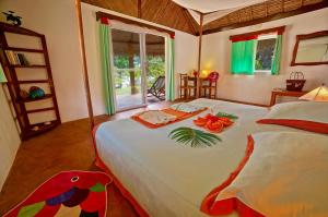 a bedroom with a bed with flowers on it at Les Tipaniers Lodge in Sainte Marie