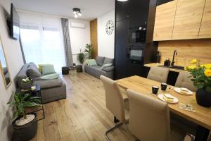 a kitchen and a living room with a dining room table at Apartament LUX in Zator