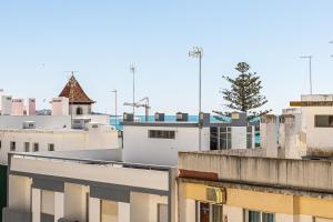 a view of roofs of buildings with a tree at Tartaruga Azul in Armação de Pêra