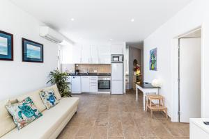 a living room with a couch and a kitchen at Tartaruga Azul in Armação de Pêra