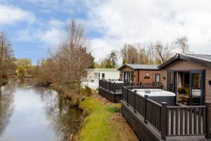 a house next to a river next to a river at Billing Aquadrome Holiday Park in Great Billing