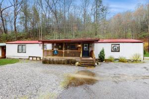una pequeña casa blanca con techo rojo en Manis Hollow, en Gatlinburg