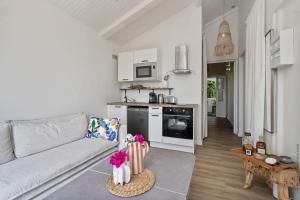 a living room with a couch and a kitchen at Le cocon Aimée in Fort-de-France