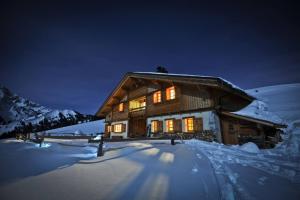 a log cabin in the snow at night at Grand Chalet - Coeur de la montagne in Mont-Saxonnex