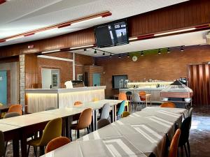 a restaurant with tables and chairs and a kitchen at Hotel Garden in Rivoli