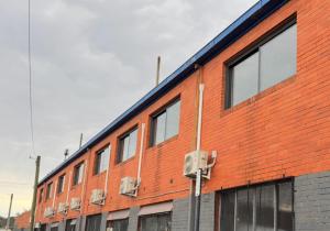 un edificio de ladrillo naranja con ventanas laterales en Chadstone Holiday Village, en Oakleigh South