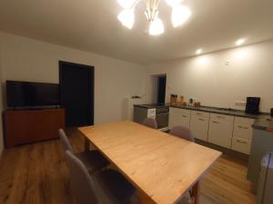 a kitchen with a wooden table and chairs in a room at Ferienwohnung Stella in Zittau +5 photos