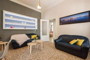 a living room with a black leather couch and a table at Geana Apartments in Chania