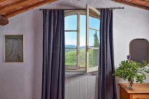 a window with purple curtains in a room at Agriturismo Il Prato in Greve in Chianti