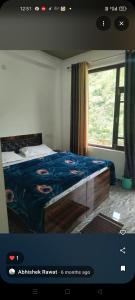 a bedroom with a bed with a blue blanket and a window at S R hotel in Kutnaur
