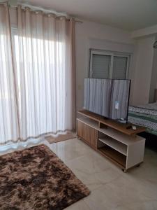 Televisyen dan/atau pusat hiburan di Loft confortável com garden