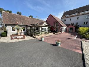 a parking lot in front of a building at Hotel ARBOR - Les Hunaudieres - Le Mans Sud - Mulsanne in Mulsanne
