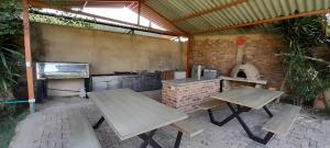 an outdoor kitchen with two picnic tables and an oven at Reserva de Santa Ines Valle de Tibasosa in Tibasosa