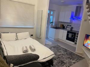 a small bedroom with a bed and a kitchen at Modern Cozy home in Watford