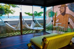 uma varanda telada com sofá e redes em Hotel Areias Belas em Maragogi