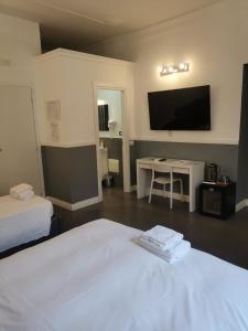 a hotel room with a bed and a table and a tv at I LOVE ROMA Guest House in Rome