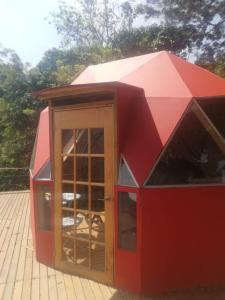 a red play house with a door in it at Ecobindu-Domo in Albán