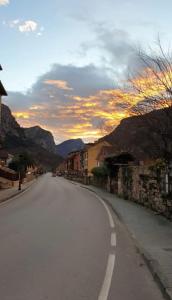 an empty street with a sunset in the mountains at La Paserina in Arenas de Cabrales