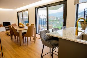 una cucina e una sala da pranzo con tavolo e sedie di Casa das Oliveiras a Vieira do Minho Altre 36 foto