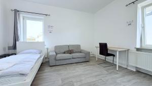 a bedroom with a bed and a desk and a chair at Komfortable Apartments Neumünster Zentrum perfekt für Beruf & Handwerk in Neumünster