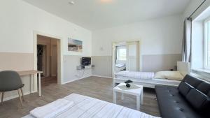 a living room with a couch and a bed at Komfortable Apartments Neumünster Zentrum perfekt für Beruf & Handwerk in Neumünster