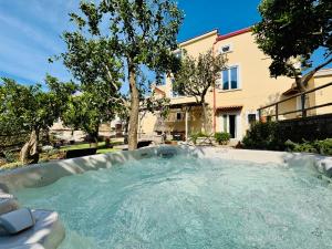 a hot tub in a yard with a building at YourHome - Antico Casale Sorrentino & Suite - Indipendent Villa in Meta