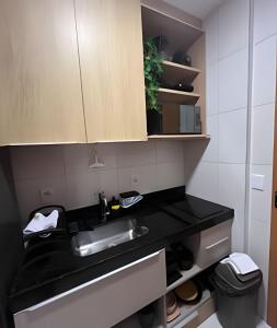 a kitchen with a sink and a black counter at Flat Luxo Alto Padrão, Praia de Muro Alto, Makia Beach Experience in Ipojuca