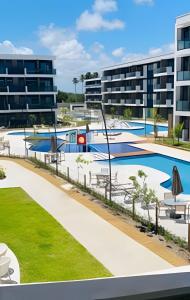 an image of an apartment complex with a swimming pool at Flat Luxo Alto Padrão, Praia de Muro Alto, Makia Beach Experience in Ipojuca