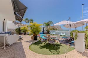 a patio with a table and chairs and umbrellas at Bungalow apartment with private pool & ocean views in Adeje