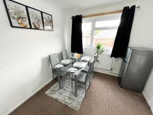 a dining room with a table and chairs and a window at 3 Bedroom House, WiFi & Free Parking in Chatham