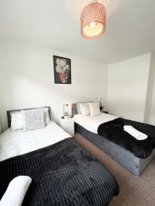 a bedroom with two beds and a chandelier at 3 Bedroom House, WiFi & Free Parking in Chatham
