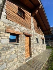 a stone building with a wooden door and windows at Casa degli iris in Quart