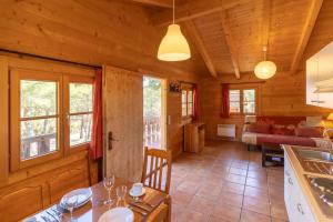 a kitchen and living room in a log cabin at Aras Rural in Aras de Olmos