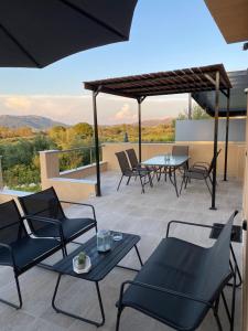 a patio with black chairs and tables and a view at Thalia's House in Pastida
