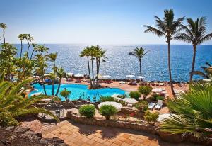 a view of a resort with a swimming pool and the ocean at 5-bedroom Villa in Playa del Duque in Adeje