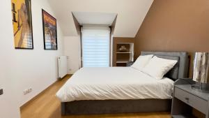 una camera da letto con un letto bianco e una finestra di Villa du Parc - 8p - Disney & Luxury Outlet a Serris