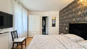 a bedroom with a bed and a flat screen tv at Villa Parc - Parking privé - Disneyland 7min - 8 P in Serris