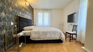 a bedroom with a bed and a tv on a wall at Villa Parc - Parking privé - Disneyland 7min - 8 P in Serris