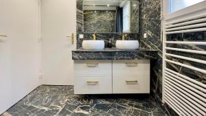 a bathroom with two sinks and a mirror at Villa Parc - Parking privé - Disneyland 7min - 8 P in Serris