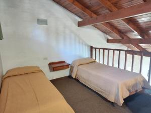 a bedroom with two beds and a wooden ceiling at Green House in Villa General Belgrano +19 photos