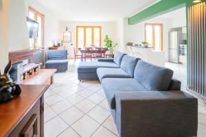 ein Wohnzimmer mit 2 blauen Sofas und einer Küche in der Unterkunft Villa Lepre - Come to the silence in Casarza Ligure