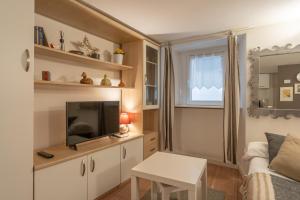ein kleines Wohnzimmer mit Fernseher und Sofa in der Unterkunft Bellano Studio 2 in Bellano