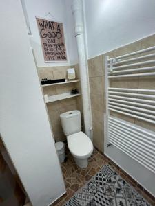 a bathroom with a toilet and a sign on the wall at LaWanda Studio in Petroşani +10 photos