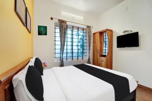 Televisyen dan/atau pusat hiburan di Super Hotel O Rose Garden Ooty Formerly New Star Cottages