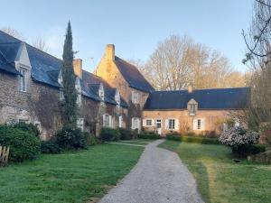 a large brick building with a pathway in front of it at Maison d'hôtes de La Roche Tabary in Bernay