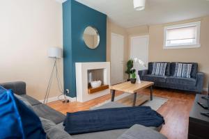 a living room with a couch and a mirror at Marina House in Bathgate