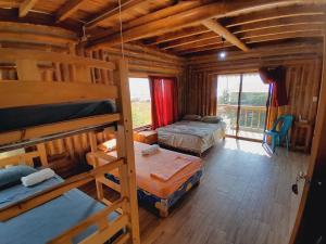 a room with two bunk beds in a log cabin at Hostal Fara in Jama