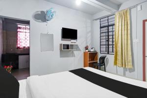 西隆Super Hotel O Lapalang Shillong的一间带床、书桌和电视的卧室